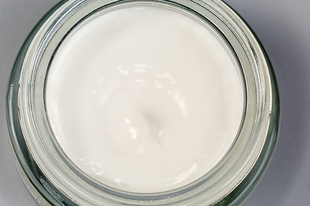 istock White cosmetic cream in open jar, top view close-up 2211143340