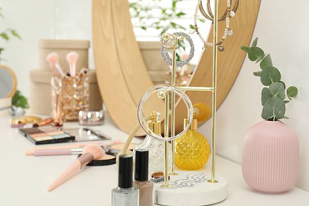 istock Makeup room. Mirror, jewelry and different cosmetic products on white dressing table indoors, closeup 2211143497