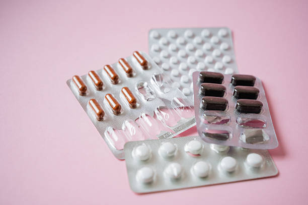 istock Three colorful pill packs are artistically arranged against a soft pink background, showcasing their vibrant hues and creating a striking composition for viewers to admire 2211144244
