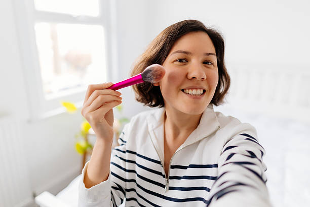 istock Woman applying make-up with brush and recording vlog 2211145469