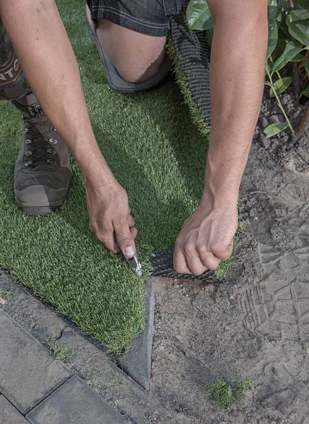 istock Cutting artifical grass with a stanley knife. 2211146029