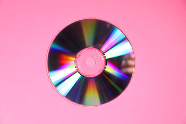 One shiny compact disc on pink background, top view