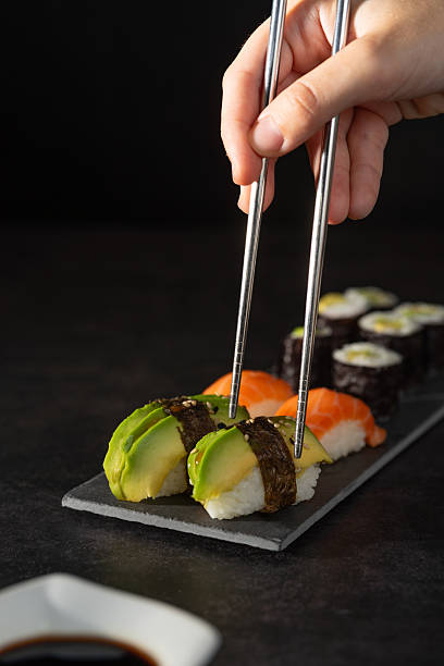 Person grabing a piece of sushi