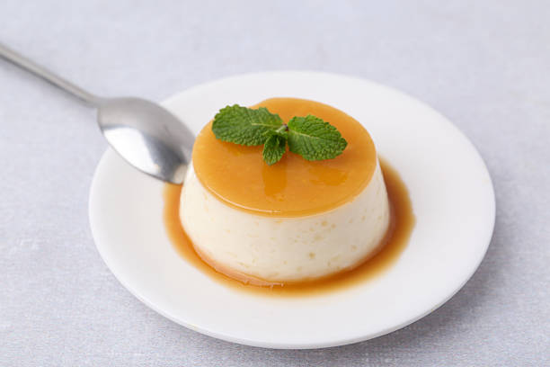 istock Tasty pudding with caramel sauce served on white table, closeup 2211149817