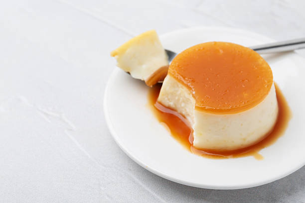 istock Tasty pudding with caramel sauce served on white textured table, closeup. Space for text 2211149829