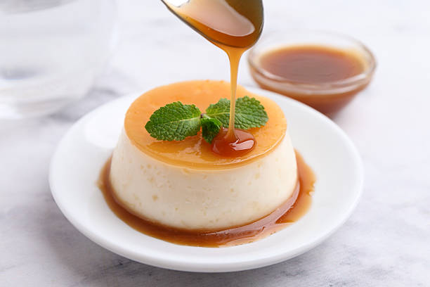 istock Tasty pudding with caramel sauce served on white marble table, closeup 2211149838