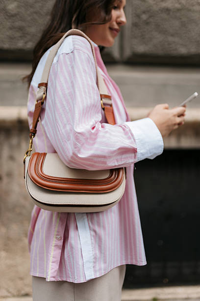 Stylish woman using smartphone while walking in the city