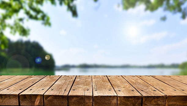 istock Empty old wooden table with summer lake in background 2211154349