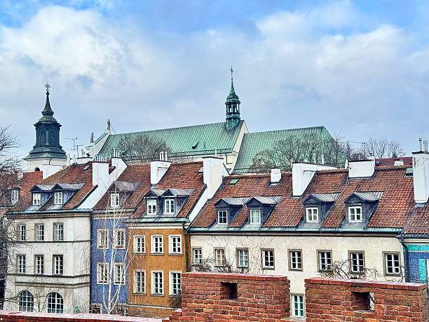 view of colorful buildings in Warsaw's Old Town with a red brick wall on a cloudy winter day