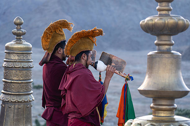 Thiksey, India - September 12, 2024: Two monks blow horns as part of the daily morning ceremony at Thiksey monastery.