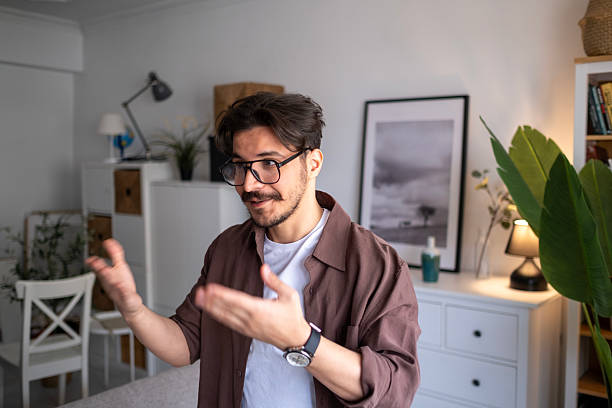 istock Confused businessman spreading hands and shrugging shoulders over gray background, I don't know 2211158201