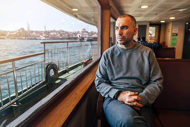 istock A man riding on a ferry, enjoying her trip 2211160000
