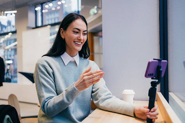 istock Woman Smiling During Video Call in a Bright Cafe Setting 2211164641