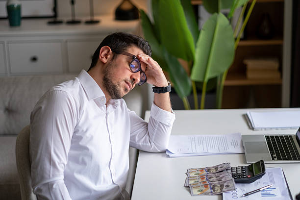 istock Upset businessman doing calculations at his desk 2211165999