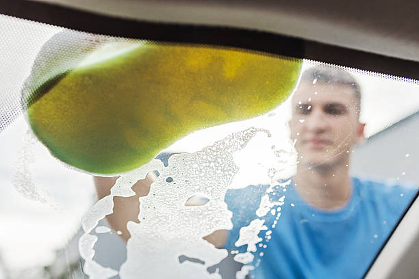 istock Close-Up of Car Windshield Being Washed With Sponge and Suds 2211167687