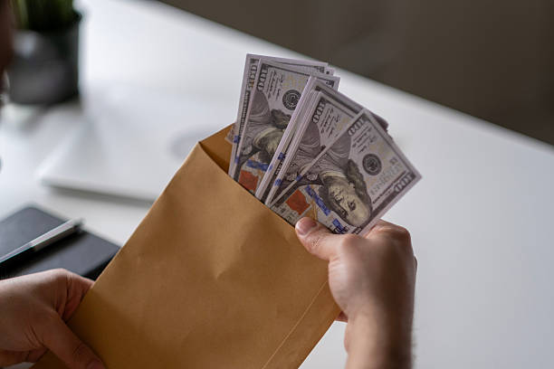 istock Man's hand holds envelope with money 2211167922