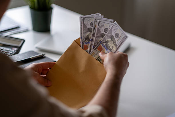 istock Man's hand holds envelope with money 2211167924