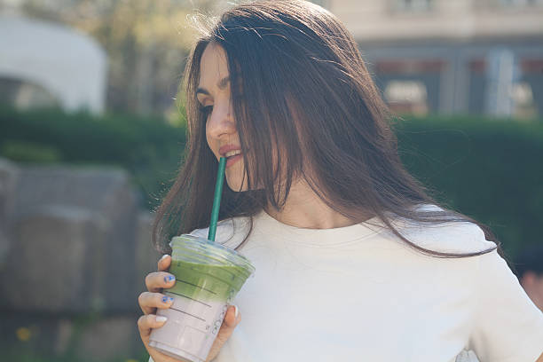 istock Young woman drinking matcha and lavender milkshake 2211169933
