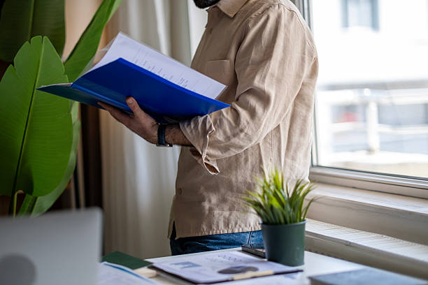 istock Mature businessman standing at table and analyzing business reports 2211172465