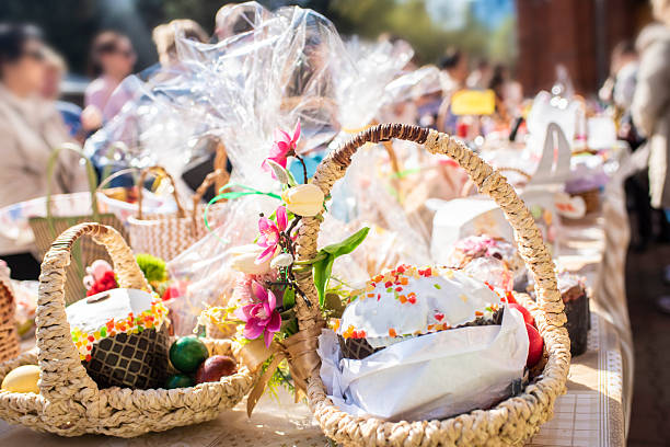 istock a basket with traditional pastries, Easter Kulich cake and colored eggs, in front of other baskets with Easter food. Many baskets are displayed on the table for the consecration and blessing 2211174096