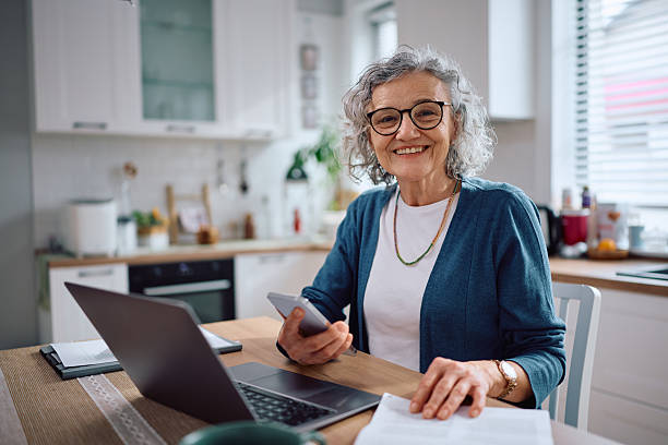 istock Happy senior woman going her home finances and looking at camera. 2211174521