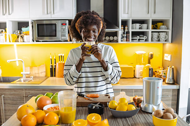 istock Smiling woman enjoying fresh juice in a bright kitchen 2211175944