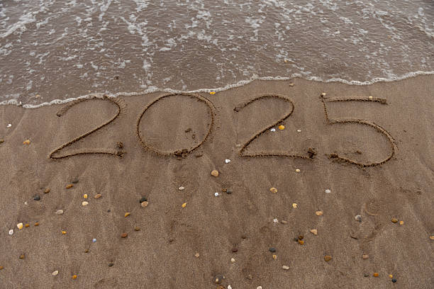 istock 2025 written in the sand on the beach. 2211178885