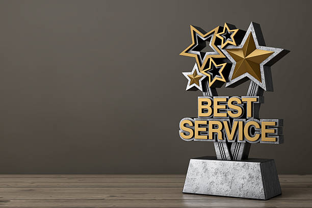Golden Best Service Business Award Trophy on a wooden table background. 3d Rendering