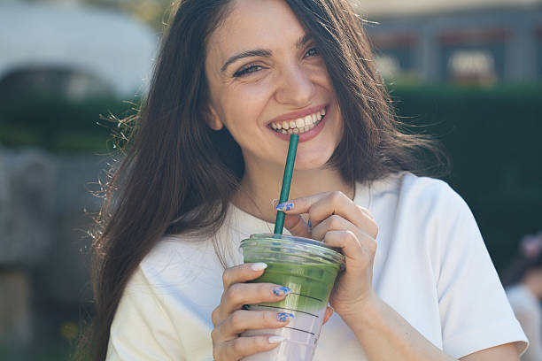 istock Young woman drinking matcha and lavender milkshake 2211183145