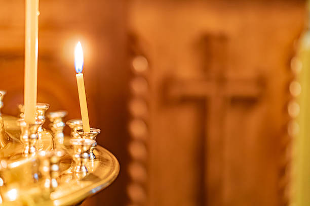 istock Image depicts a group of candles in a religious or ceremonial setting, with two blue-flamed candles as the main focus Other candles surround them, creating an impression of a larger ceremony 2211184607