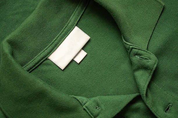 istock Blank white laundry care clothes label on green shirt fabric texture background 2211185180
