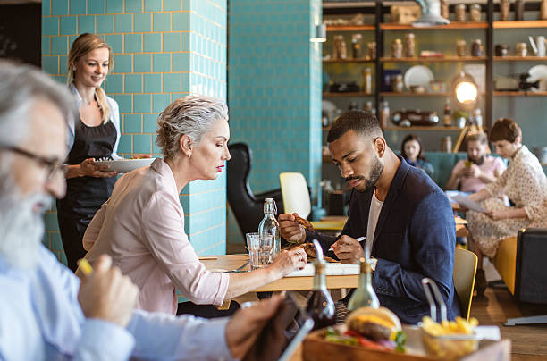 istock Focused Business Discussion Between Diverse Professionals in Cozy Bistro 2211185267