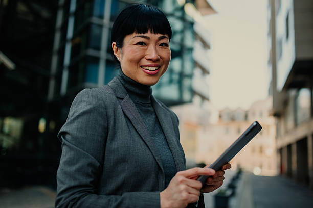 istock Smiling businesswoman using digital tablet in urban setting 2211185704
