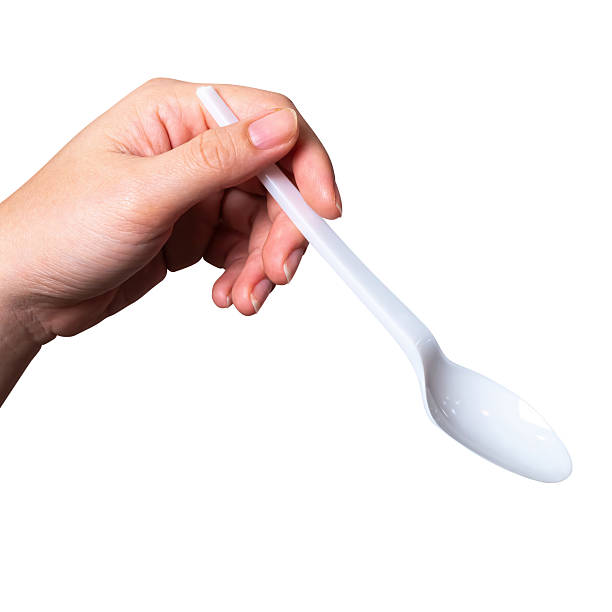 istock Female hand holding a white plastic spoon isolated on white background. 2211187500