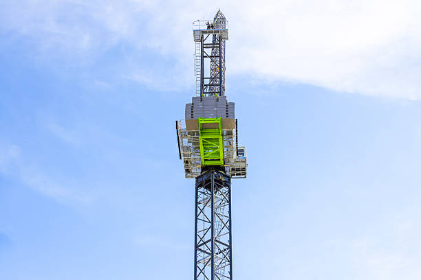 istock Closeup low angle view of modern tower crane against blue sky, background with copy space 2211189621