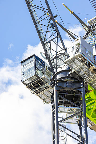 istock Closeup low angle view of modern tower crane against blue sky, background with copy space 2211189967
