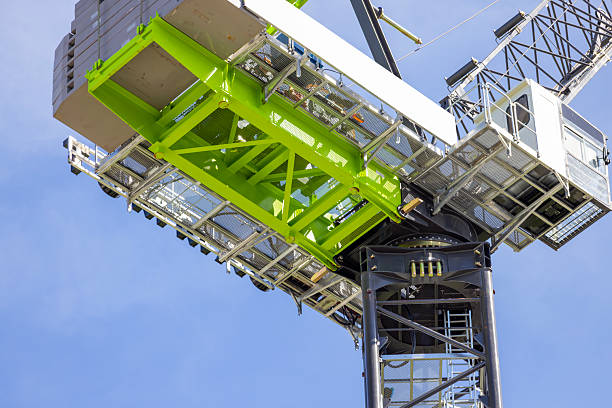 istock Closeup low angle view of modern tower crane against blue sky, background with copy space 2211190198