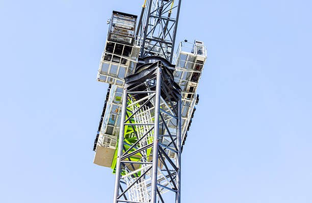 istock Closeup low angle view of modern tower crane against blue sky, background with copy space 2211190445