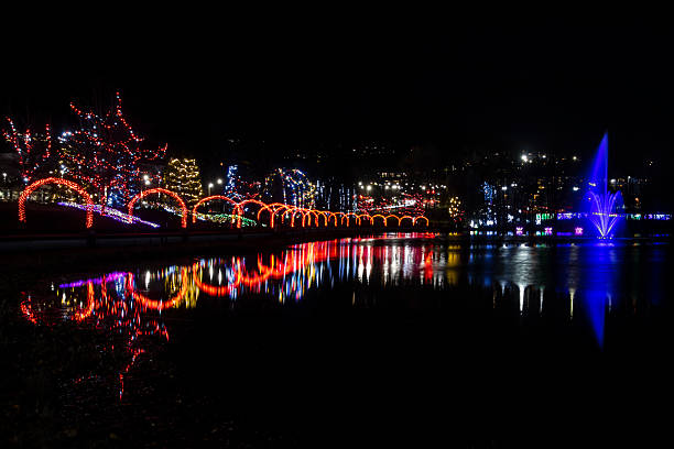 istock Colorful light display over water reflects vibrant holiday decorations at night in a quiet park 2211193601