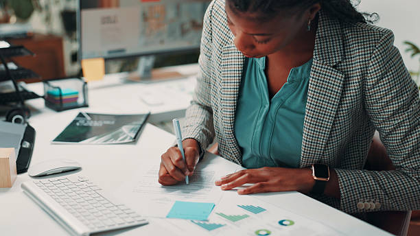 istock Black woman, documents and notes by computer in office for project, admin and review for proposal. Person, paperwork and graphs for research, planning or feedback for perspective at creative agency 2211193661