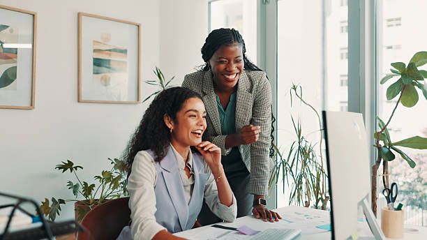 istock Teamwork, business people and women with computer, funny and help with conversation, publishing and joke. Employees, laughing or mentor in workplace, online humor or female empowerment with email 2211193718