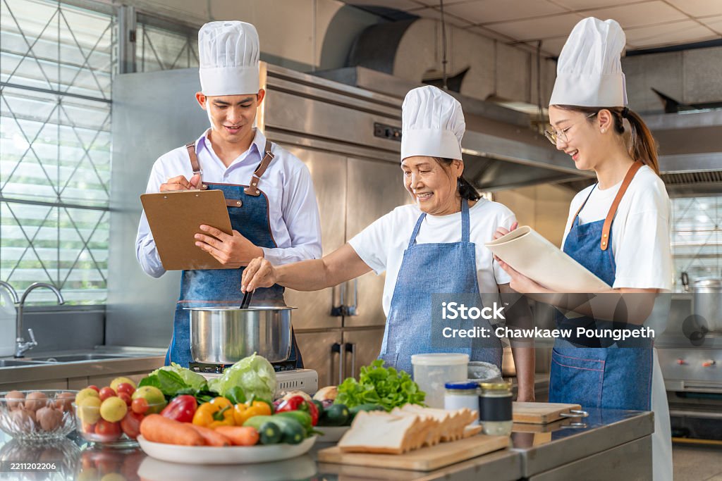Chef Intructors Senior Female Chef Instructor Showing Her Students How To Cook While ...