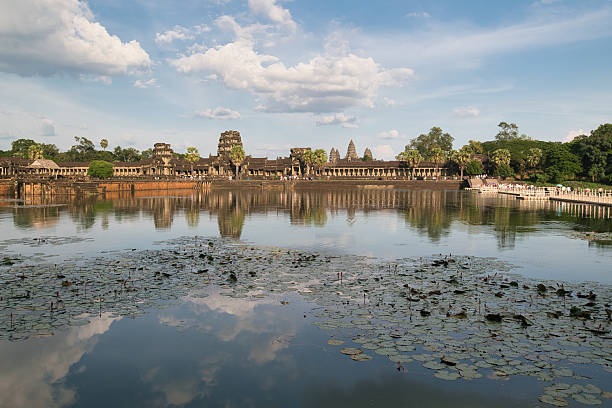 The ancient castle is located behind a large pond and in the pond there are lotuses, on a clear day
