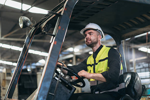 istock Engineers work in the factory. Technicians repair the engine. A worker drives a forklift in the warehouse. 2211209669