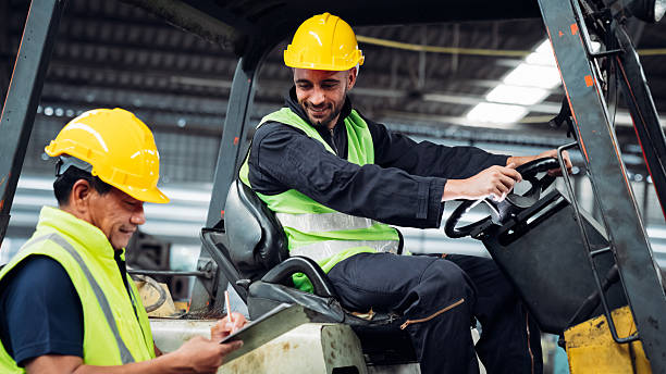istock Engineers work in the factory. Technicians repair the engine. A worker drives a forklift in the warehouse. 2211209817