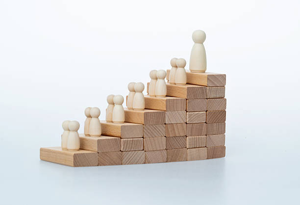 istock Wooden figures standing on staircase 2211210070