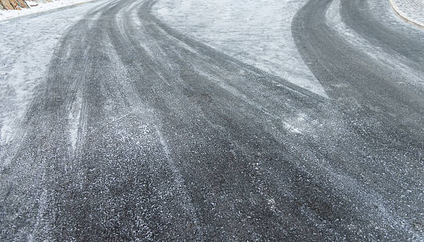 istock Car tire tracks on the snow road 2211210667