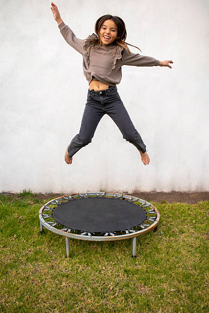 Excited African American Teenage Girl Celebrating and Jumping in a Park.. Copy space available.