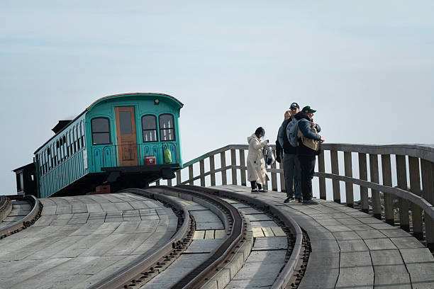 Mt. Washington, New Harmpshire, USA - September 30, 2023: Tourists stand next to cog train that delivered them to the summit of Mt Washington