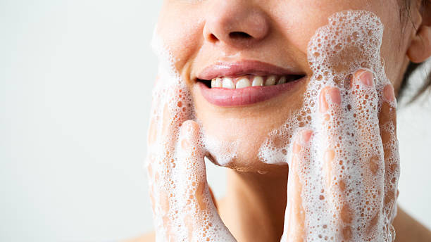 istock Beautiful woman washing her face 2211214201